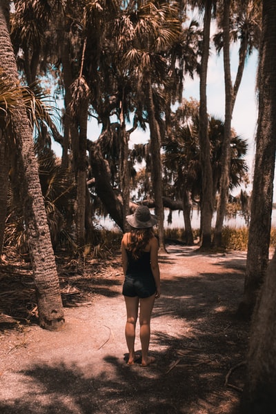 Standing under the palm trees near water bodies of women
